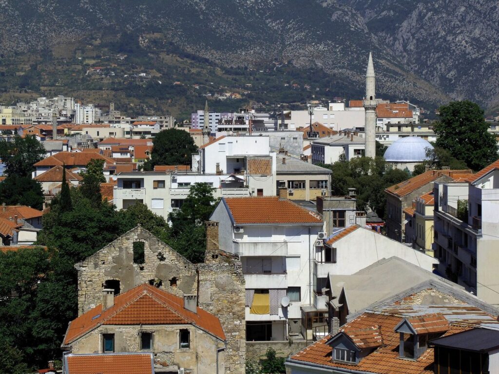 Koski Mehmed Paşa Camii'nden Mostar'ın kiremit çatıları, minareleri ve dağ manzarası
